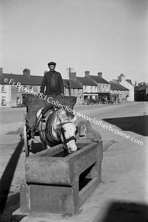 STREET WITH HORSE DRINKING FROM TROUGH